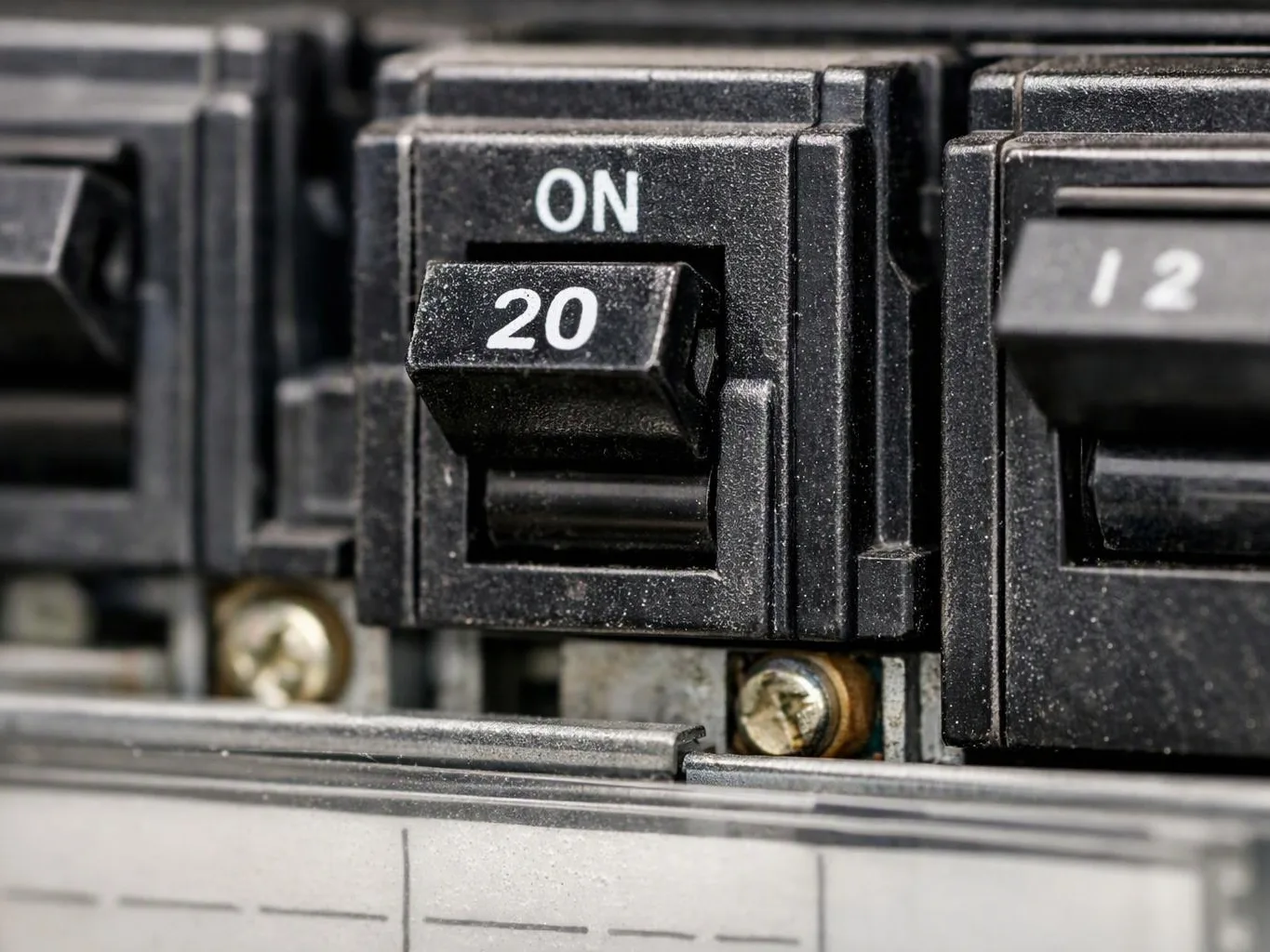 Close-up of a black electrical breaker switch labeled on and 20 inside a panel
